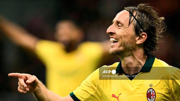 AC Milan's Croatian midfielder #14 Luka Modric celebrates after scoring his team first goal during the Italian Serie A football match between AC Milan and Bologna at San Siro stadium in Milan, northern Italy, on September 14, 2025. - AFP