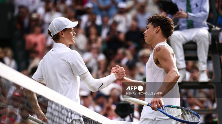 Winner Italy’s Jannik Sinner shakes hands with US player Ben Shelton at the end of their men’s singles quarter-final tennis match on the tenth day of the 2025 Wimbledon Championships at The All England Lawn Tennis and Croquet Club in Wimbledon, southwest London, on July 9, 2025. - AFP