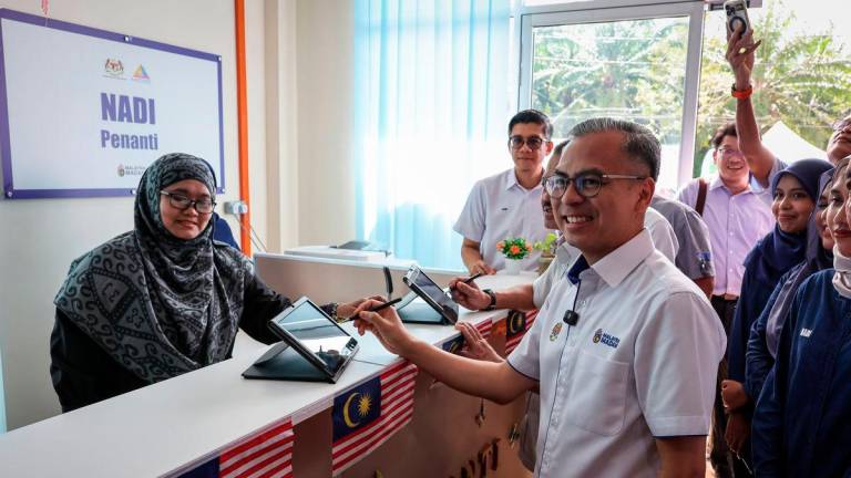 Communications Minister Datuk Fahmi Fadzil signed the attendance during his visit to the National Information Dissemination Centre (NADI) Penanti today. – BERNAMA