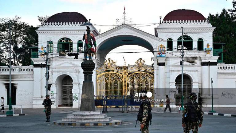 Army personnel stand guard near Singha Durbar, the main administrative building for the Nepal government, after it was set ablaze by protesters in Kathmandu on September 11, 2025. - AFP