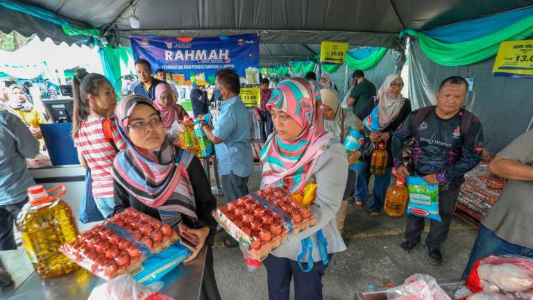 Shoppers at a Rahmah sales event purchasing essential goods under the government aid scheme. – AMIRUL SYAFIQ/THESUN