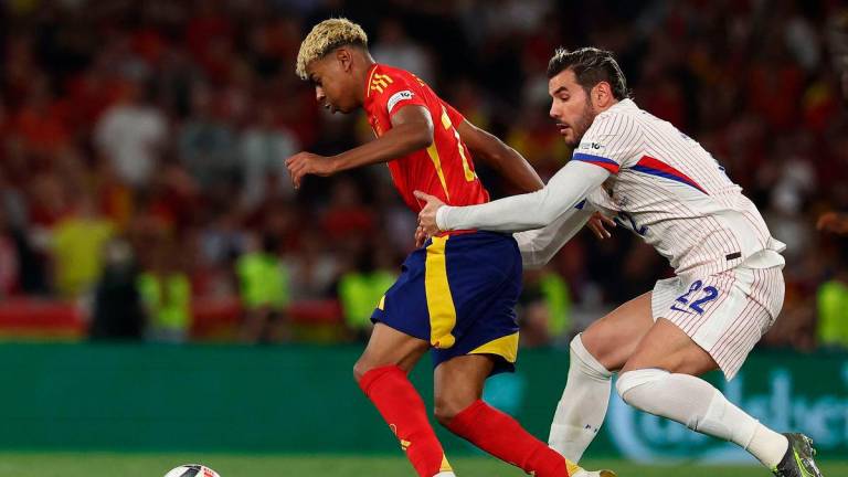 Spain’s forward #19 Lamine Yamal is pulled back by France’s defender #22 Theo Hernandez during the UEFA Nations League semi-final football match between Spain and France in Stuttgart, southwestern Germany, on June 5, 2025. AFP
