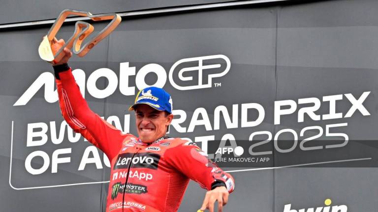 Winner Ducati Lenovo team's Spanish rider Marc Marquez jumps on the podium as he celebrates after the Austrian MotoGP Grand Prix at the Red Bull Ring race track in Spielberg, Austria, on August 17, 2025. - AFP