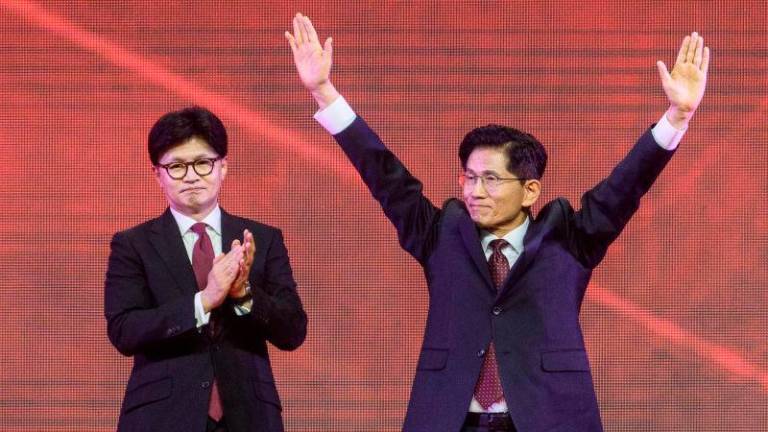 Former labour minister Kim Moon-soo (R) celebrates next to ex-party chief Han Dong-hoon after winning the final race to choose South Korea’s conservative People Power Party’s (PPP) candidate for the upcoming presidential election, during a national convention of the party in Goyang on May 3, 2025. AFPpix