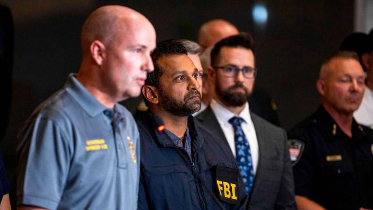 FBI director Kash Patel, right, listens as Governor of Utah Spencer Cox speaks during a press conference at Utah Valley University on September 11, 2025 in Orem, Utah. Authorities have released a “person of interest” as they search for the suspect who shot and killed Kirk, founder of Turning Point USA, while he was speaking at an event for his “American Comeback Tour”. Michael Ciaglo/Getty Images/AFP (Photo by Michael Ciaglo / GETTY IMAGES NORTH AMERICA / AFP)