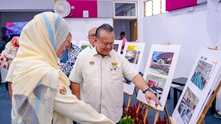 Works Minister Datuk Seri Alexander Nanta Linggi views images of the school construction project during the Handover Ceremony of the New School Construction Project at the Precinct 15 School Complex today. - BERNAMAPIX