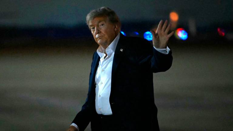US President Donald Trump waves upon arrival at Joint Base Andrews in Maryland, on August 15, 2025. Donald Trump and Vladimir Putin made no breakthrough on Ukraine at their high-stakes summit on August 15, 2025, pointing to areas of agreement and rekindling a friendship but offering no news on a ceasefire. After an abrupt ending to three hours of talks with aides, Trump and Putin offered warm words but took no questions from reporters -- highly unusual for the media-savvy US president Photo by ANDREW CABALLERO-REYNOLDS / AFP