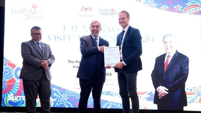 Timbalan Perdana Menteri Datuk Seri Dr Ahmad Zahid Hamidi menyampaikan Sijil Rakan Kongsi Strategik kepada Ketua Destinasi Marc James (kanan) pada Majlis Pelancaran Tahun Melawat Malaysia 2026 (TMM2026) di United Kingdom (UK), semalam. BERNAMA