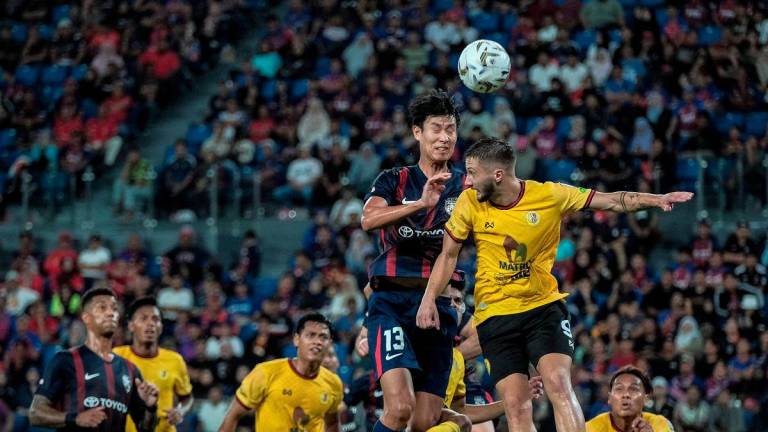 Pemain JDT Park Juenhong (dua, kanan) melepaskan tandukan sambil dihalang pemain Negeri Sembilan FC Jovan Motika (kanan) pada saingan Liga Super Malaysia 2025/2026 di Stadium Sultan Ibrahim hari ini. - fotoBERNAMA