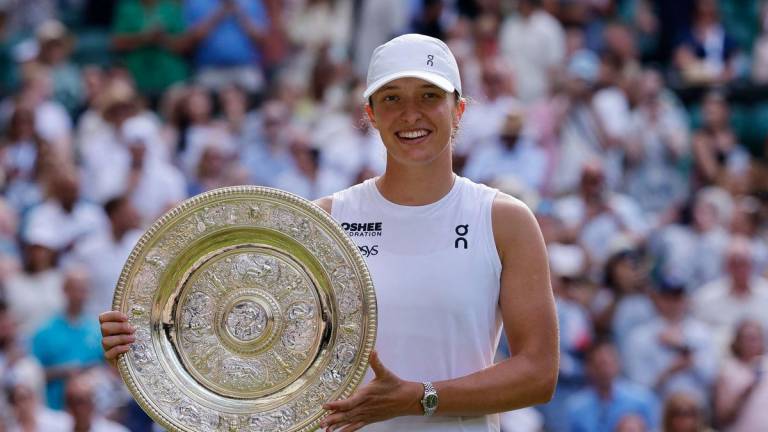 Poland’s Iga Swiatek celebrates with the trophy after winning the women’s singles final at Wimbledon against Amanda Anisimova of the U.S. REUTERS