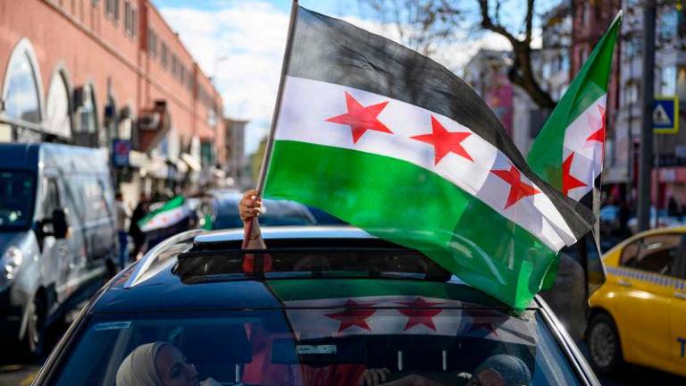 People wave Syrian flags while driving cars as Syrian residents in Turkey celebrate the end of the Baath rule in Syria after rebel fighters took control of Damascus overnight, in Istanbul - AFPpix