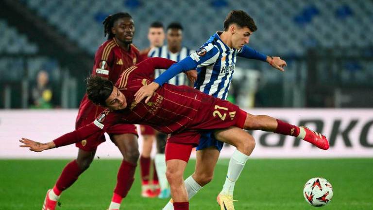 Roma's Argentine forward #21 Paulo Dybala fights for the ball with FC Porto's Argentine midfielder #25 Tomas Perez during the UEFA Europa League knockout round play-off 2nd leg football match between AS Roma and FC Porto at the Olympic stadium in Rome, on February 20, 2025. - AFPPIX