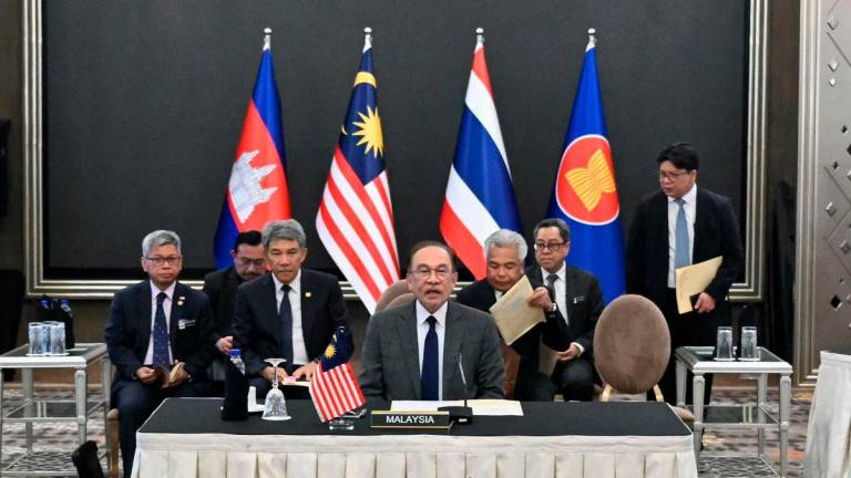 Malaysia’s Prime Minister Anwar Ibrahim (C) mediates talks with Cambodia’s Prime Minister Hun Manet and Thailand’s acting Prime Minister Phumtham Wechayachai on a possible ceasefire between Thailand and Cambodia in Putrajaya on July 28, 2025. (Photo by MOHD RASFAN / POOL / AFP)