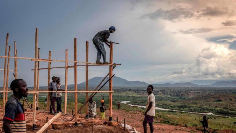 Internally displaced people, forced from their homes by rising waters of Lake Tanganyika, build a new structure at the Gateri IDP camp in Gateri, on May 5, 2025. - AFPPIX