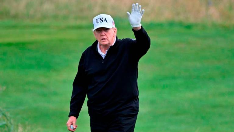 US President Donald Trump reacts as he plays golf at the Trump Turnberry Golf Courses, in Turnberry on the south west coast of Scotland on July 26, 2025 - AFP