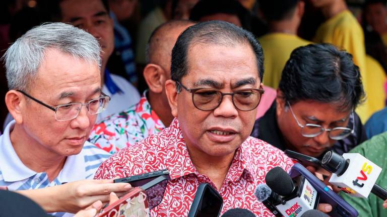Defence Minister, Datuk Seri Mohamed Khaled Nordin (centre), speaks to reporters after attending the Meet and Greet Session with the Chinese Community of Kota Tinggi at the Muafakat Food Court today. – BERNAMA