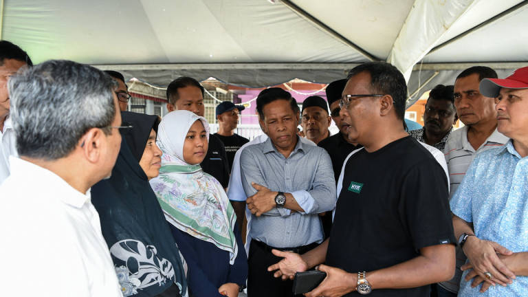 Chairman of the Kedah MADANI Youth Association, Datuk Zuraidi Rahim, speaks with Putri Qisya Nur Izzat, 12, who lost both her parents and four siblings in the tragedy at Sungai Korok last Saturday, during a visit to her relative’s home in Taman Sri Aman here. - BERNAMA