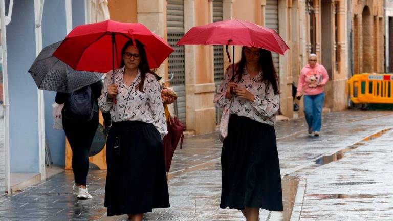 People hold umbrellas as it rains in Paiporta, near Valencia, Spain September 30, 2025. REUTERS/Eva Manez