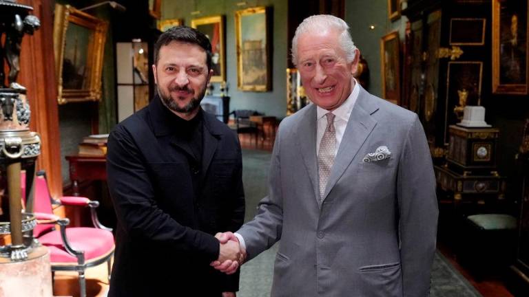 Britain’s King Charles III shakes hands with Ukraine’s President Volodymyr Zelensky during an audience at Windsor Castle, west of London on June 23, 2025. (Photo by Jonathan Brady / POOL / AFP)