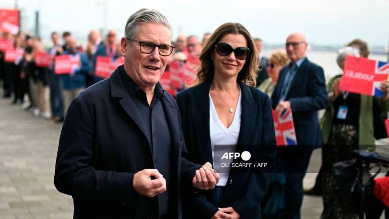 Britain's Prime Minister Keir Starmer speaks to members of the media as he arrives with his wife Victoria ahead of the annual Labour Party conference in Liverpool, north-west England, on September 27, 2025. - AFP