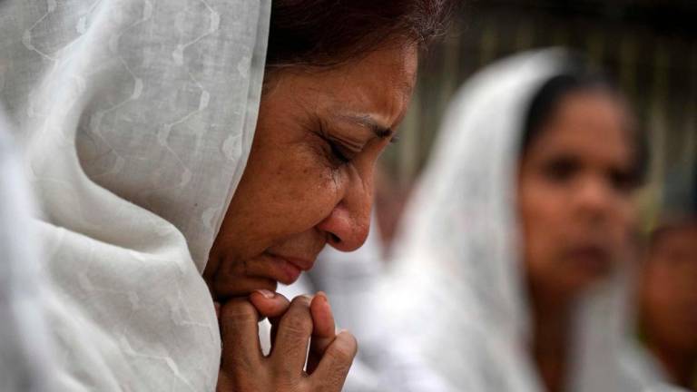 A relative mourns during a special prayer organised for the victims killed in the Air India flight crash before the funeral ceremony in Ahmedabad on June 15, 2025.