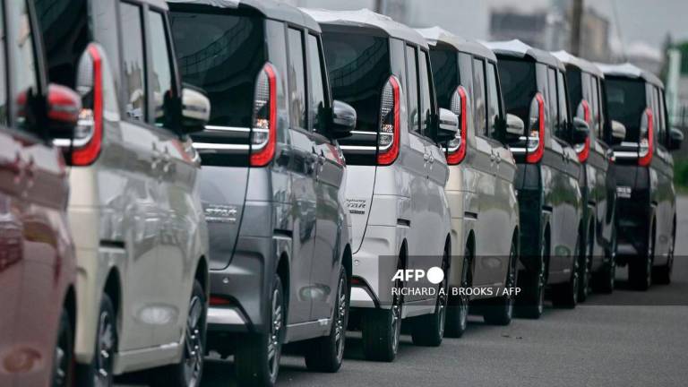 Vehicles sit lined up on a lot near the docks at the Port of Nagoya, Aichi prefecture on June 2, 2025. - AFP