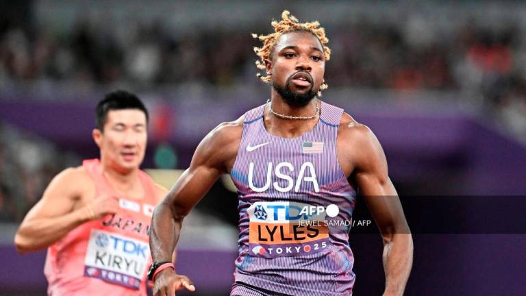 Japan's Yoshihide Kiryu (L) and US sprinter Noah Lyles react after competing in the men's 100m heats during the World Athletics Championships in Tokyo on September 13, 2025. - AFP