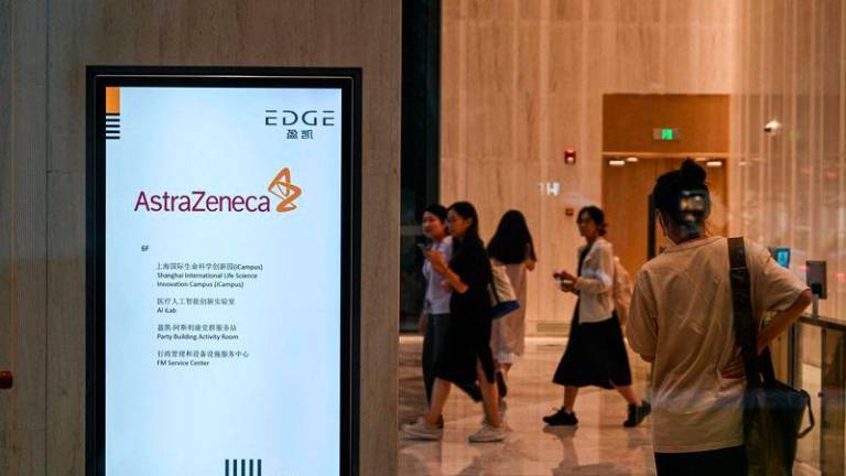 People walk in the access area of the AstraZeneca office in Shanghai - AFPpix