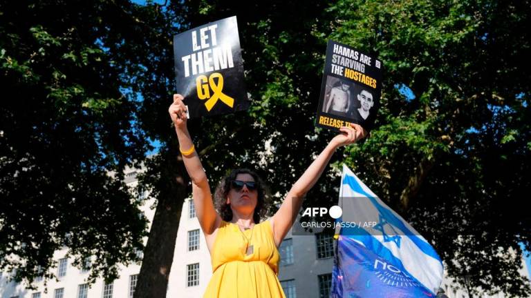A person holds placards during a ‘National march for the Hostages’ organised by Stop the Hate UK, in central London on August 10, 2025. (Photo by CARLOS JASSO / AFP)