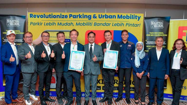 Selangor State Executive Councillor for Islamic Affairs, Halal Industry, and the Cultivation of Science, Technology and Innovation, Dr Mohammad Fahmi Ngah (centre), poses for a photo after the presentation of the Malaysia Book of Records (MBOR) certificates for the achievements of the “Most Extensive Integrated Smart Parking Application in Malaysia” and the “Highest Number of Parking Payment Transactions in a Single Day in Malaysia.” The certificates were presented by MBOR representative Megat Faris Hussein Megat Muzaffar Shah (fourth from right) to Flexi Parking representative Lai Thiam Sin (fifth from right) during the MBOR Awards Presentation Ceremony at the DoubleTree by Hilton i-City, Shah Alam, today. – BERNAMA