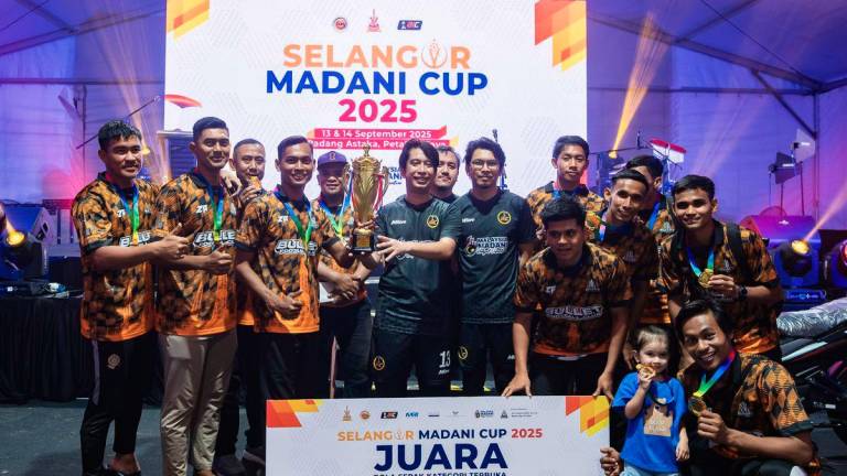 Deputy Minister of Youth and Sports, Adam Adli Abdul Halim (centre) presents the trophy to Bullet FC, the champions of the open football category at the 2025 MADANI Football Cup State-level Championship in Selangor, held at Padang Astaka today. Also present was the Political Secretary to the Minister of Finance, Muhammad Kamil Abdul Munim (centre, fifth from left). - BERNAMA