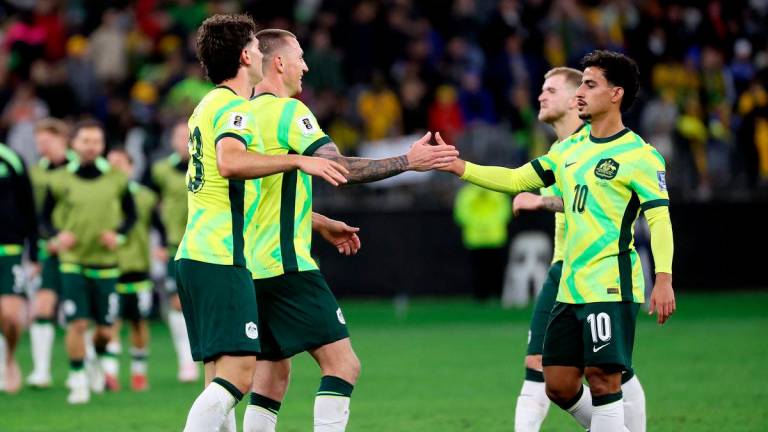 Australia’s Daniel Arzani (R) celebrates victory with teammates after the 2026 FIFA World Cup Asian Qualifier football match between Australia and Japan at Optus Stadium in Perth on June 5, 2025. (Photo by COLIN MURTY / AFP)