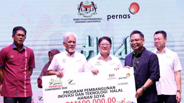 Menteri Pembangunan Usahawan Dan Koperasi Datuk Ewon Benedick menyampaikan sijil penyertaan kepada peserta program Halal Francise Conference di Meridien Hotel hari ini. - BERNAMA