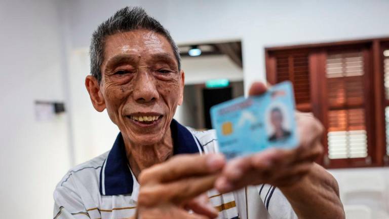 Chan Weng Poh, 83, menunjukkan kad pengenalan Kewarganegaraan Malaysia yang diterimanya pada Program Kewarganegaraan Pulau Pinang hari ini. - BERNAMA