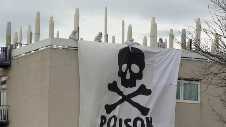 This image grab taken from AFPTV footage shows Extinction Rebellion and Youth for Climate activists deploying a giant banner depicting a skull and bones, bearing the message “Poison”, atop a structure inside the Arkema chemical plant after they entered the site to protest against pollution caused by polyfluoroalkyl substances (PFAS), in Pierre-Benite, south of Lyon, central-eastern France, on March 2, 2024/AFPPix