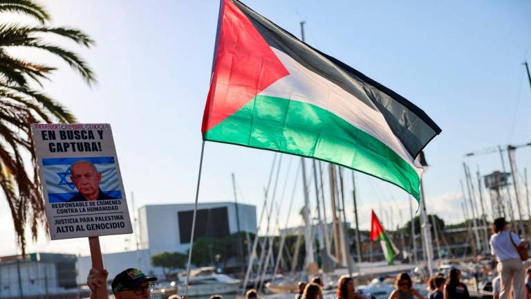 Fernando Barrena, 76, holds a Palestinian flag and a sign with the image of Israeli Prime Minister Benjamin Netanyahu, ahead of the Global Sumud Flotilla, a humanitarian expedition to Gaza, at the port of Barcelona, Spain August 31, 2025. REUTERS/Nacho Doce