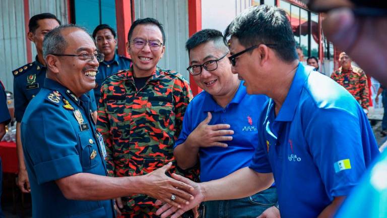 Deputy Director-General (Operations) of the Malaysian Fire and Rescue Department (JBPM), Datuk Ahmad Izram Osman, shakes hands with volunteer firefighters during the Launch Ceremony of the JBPM Water Activity Safety Council Centre of Excellence at the Fire Department Marine Unit Base in Mak Mandin today. – BERNAMA