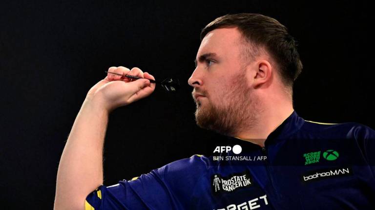 England’s Luke Littler plays against England’s Stephen Bunting during their PDC World Darts Championship semi-final at Alexandra Palace in London on January 2, 2025. (Photo by Ben STANSALL / AFP)