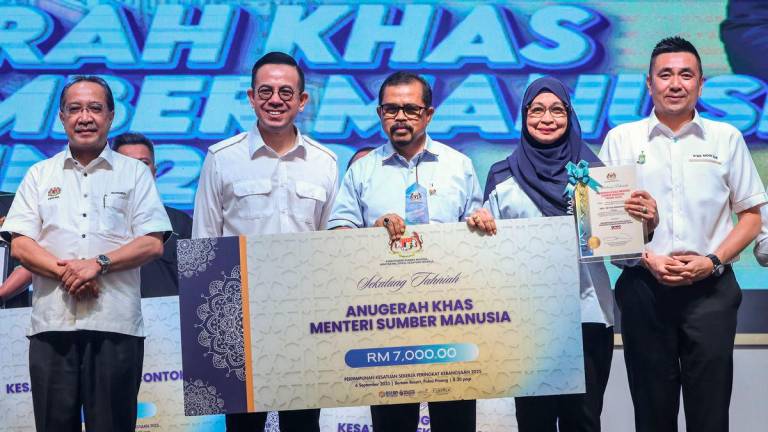 Menteri Sumber Manusia Steven Sim Chee Keong (dua, kiri) menyampaikan Anugerah Khas Menteri Sumber Manusia kepada Presiden Kongres Kesatuan Pekerja-Pekerja di Dalam Perkhidmatan Awam (CUEPACS) Datuk Dr Adnan Mat (tiga, kanan) pada Perhimpunan Kesatuan Sekerja Peringkat Kebangsaan 2025 hari ini- fotoBERNAMA