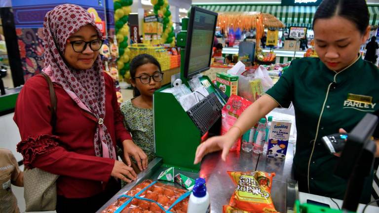 Sumbangan Asas Rahmah (SARA) recipients purchased essential items using the aid at Farley Supermarket yesterday. - BERNAMA