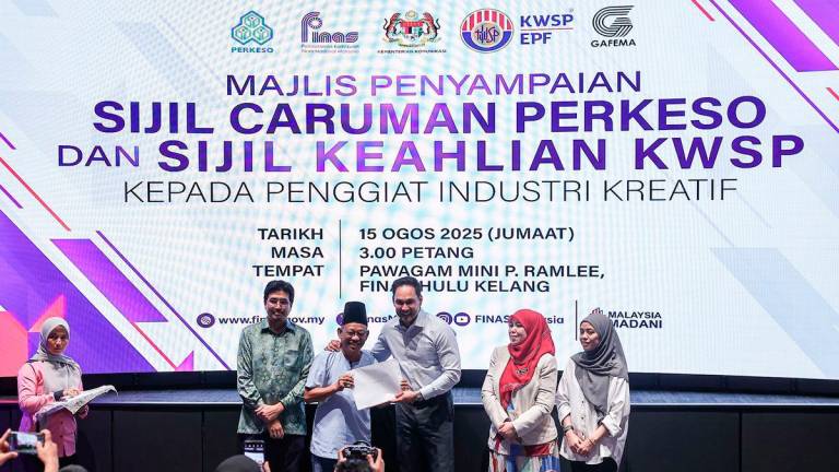 National Film Development Corporation Malaysia (Finas) chairman Datuk Gerald Hans Isaac (third, right) with veteran actor and comedian Sharizan Ahmad (second, left) at the presentation ceremony of the Social Security Organisation (Perkeso) contribution certificates and Employees Provident Fund (EPF) membership certificates to creative industry practitioners at the Finas building today. - BERNAMA
