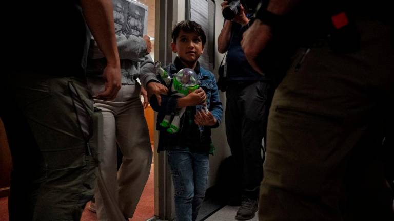 A migrant child walks out of a courtroom with a guardian as ICE agents wait to make detainments at U.S. immigration court in Manhattan, in New York City, U.S., August 6, 2025. - REUTERSPIX
