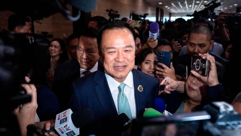 Bhumjaithai Party leader Anutin Charnvirakul (C) is surrounded by media members as he leaves a press conference after securing the backing of opposition People’s Party to serve as Thailand’s next prime minister at the parliament in Bangkok on September 3, 2025. Thailand’s acting prime minister has moved to dissolve parliament, his party said on September 3, 2025 after the largest opposition party backed a rival candidate for prime minister. (Photo by Chanakarn Laosarakham / AFP)