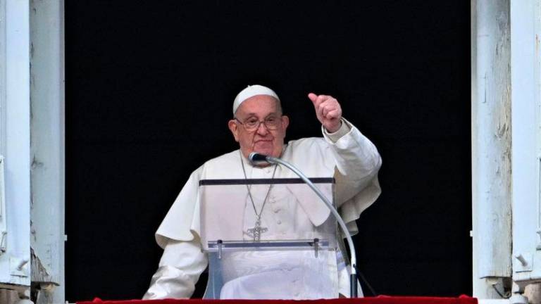 Pope Francis gestures to the crowd from the window of the Apostolic Palace overlooking St Peter’s Square during the Epiphany Angelus prayer, in the Vatican, on January 6, 2025. - AFPpix