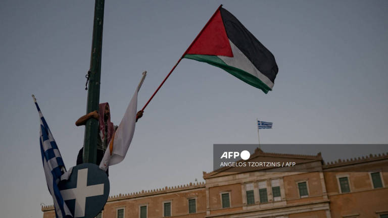 A demonstrator waves a palestinian flag during a protest in support of Palestinians and calling against the ongoing food shortages in the Gaza Strip, in Athens on July 24, 2025. - AFP