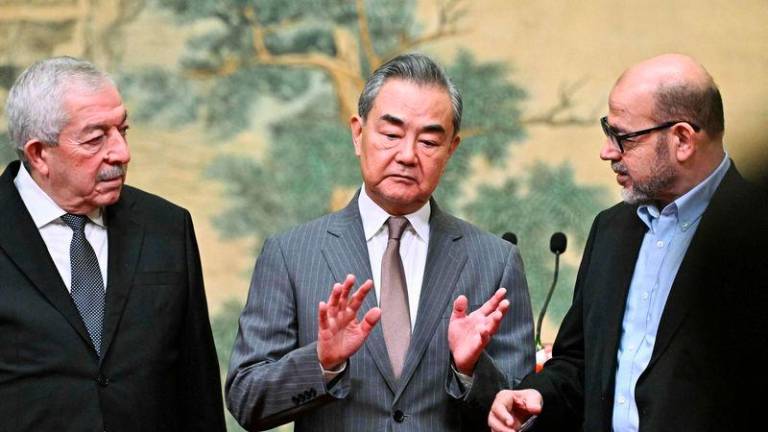Mahmoud al-Aloul, Vice Chairman of the Central Committee of Palestinian organization and political party Fatah, China’s Foreign Minister Wang Yi, and Mussa Abu Marzuk, senior member of the Palestinian Islamist movement Hamas, attend an event at the Diaoyutai State Guesthouse in Beijing - AFPpix