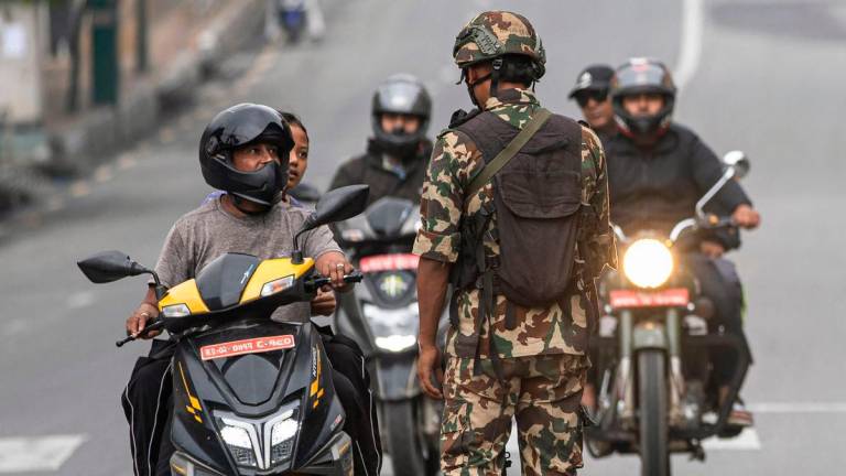 Army personnel inspect identity proof and documents of commuters along a street as part of security measures imposed in Kathmandu on September 10, 2025. (Photo by PRABIN RANABHAT / AFP)