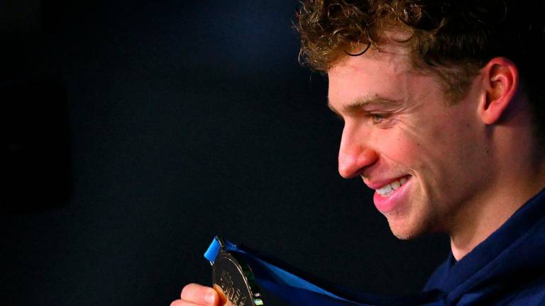 France’s swimmer Leon Marchand celebrates on the podium of the men’s 200m individual medley swimming event during the 2025 World Aquatics Championships in Singapore on July 31, 2025. - François-Xavier MARIT / AFP