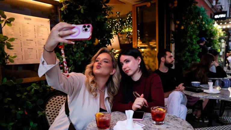 Women take a selfie at a cafe on Friday evening in the Patriarch’s Ponds district, an upscale Moscow neighbourhood, on May 30, 2025. (Photo by STRINGER / AFP)