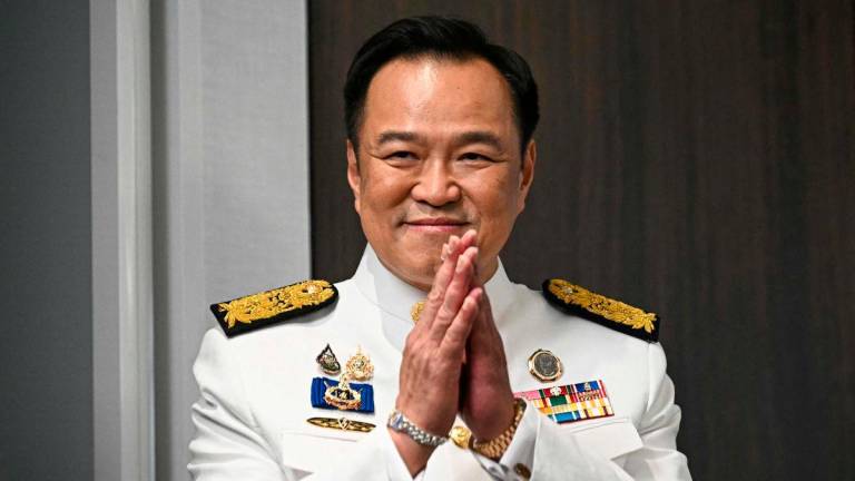 Thailand’s new prime minister Anutin Charnvirakul greets media representatives as he arrives to deliver remarks after the royal endorsement ceremony, at the Bhumjaithai Party’s headquarters in Bangkok on September 7, 2025. (Photo by Lillian SUWANRUMPHA / AFP)
